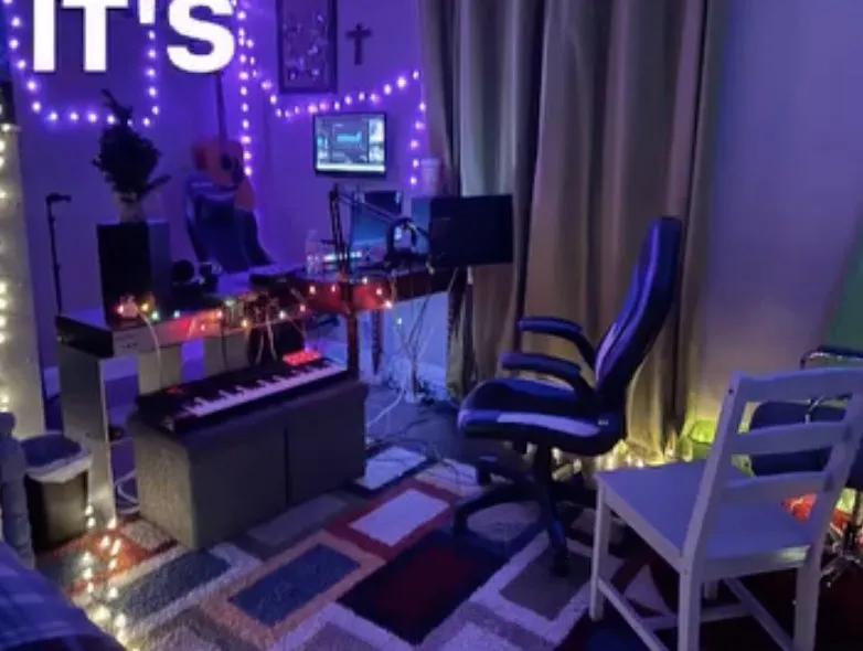 A purple-lit music room with a desk and chair