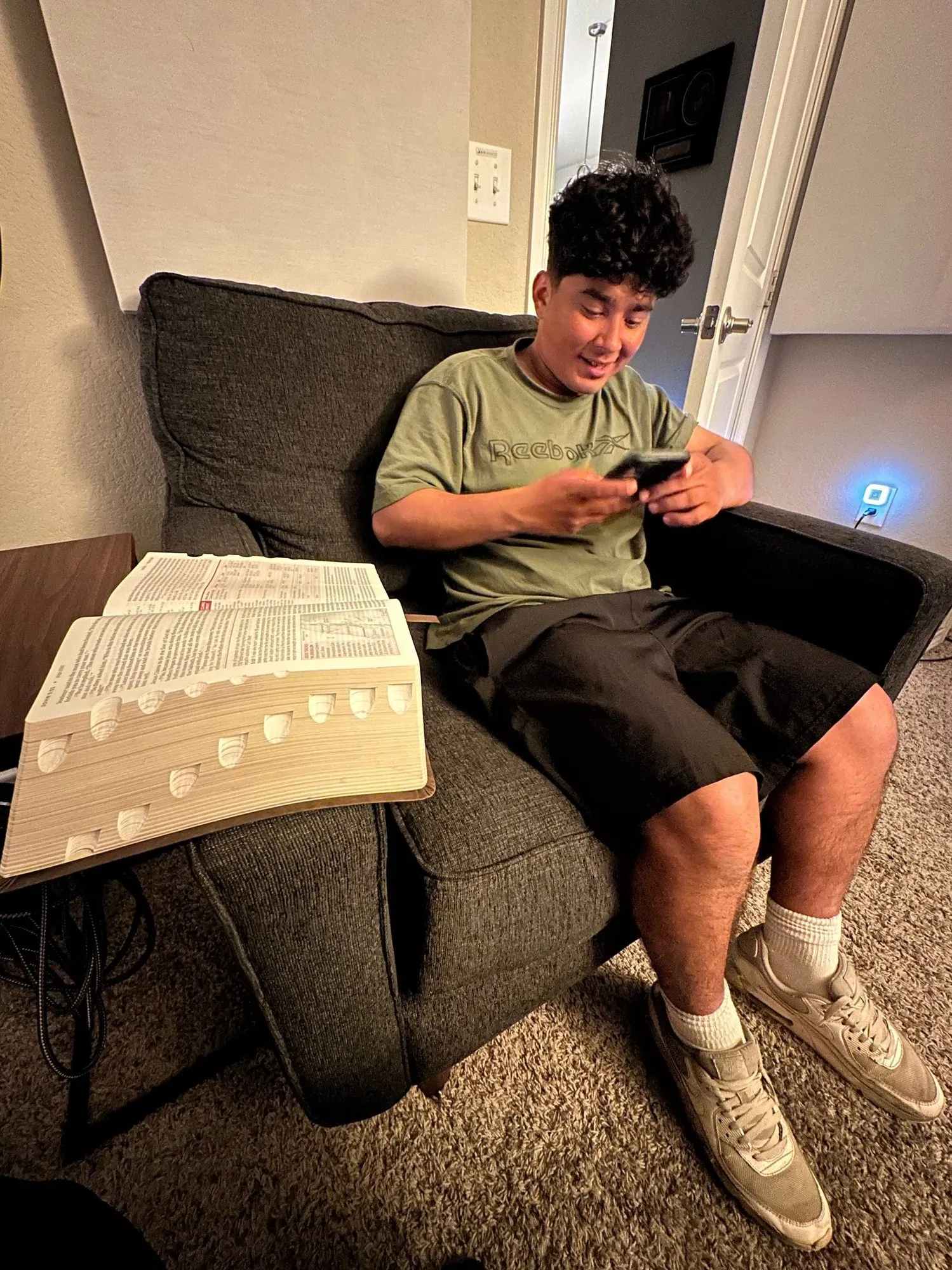 A young man relaxing on a couch with his phone