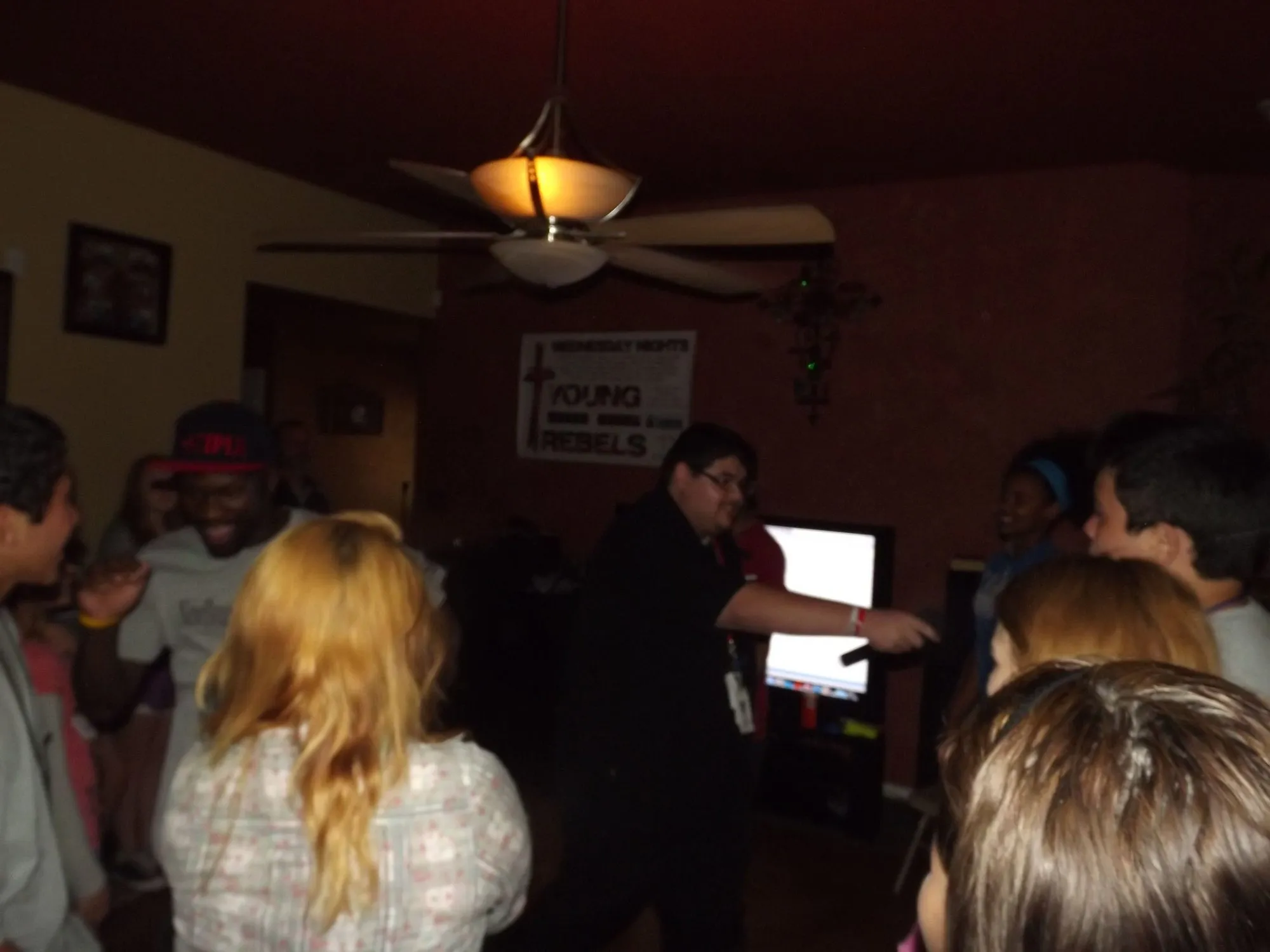 Teens dancing in a dim living room