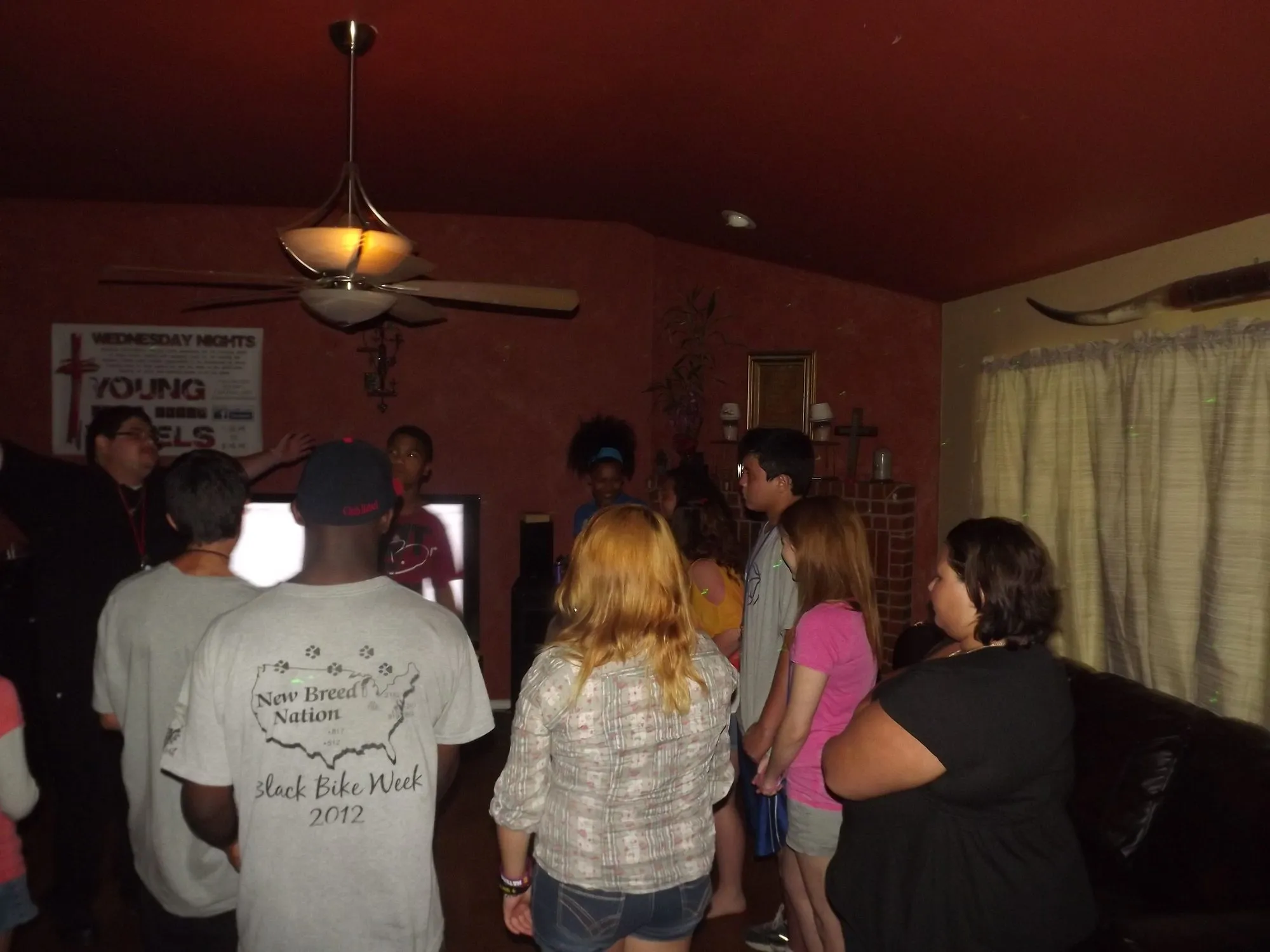 Teens and kids gathered with a TV in the background